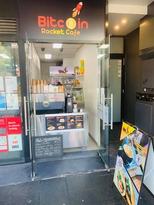 Takeaway only. The Bitcoin Rocket Cafe is tiny — sandwiched between a post office and a bank
